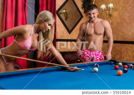 Young couple playing billiards in sauna 35010014