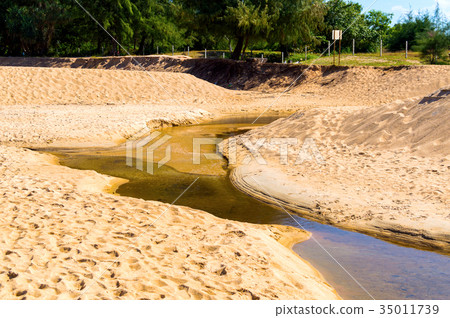 Sand beach pollution. Black water in creek on sand Sand beach pollution. Black water in creek on sand 35011739