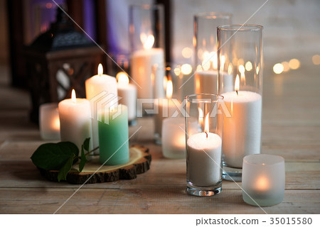 Burning candles on wooden logs resting 35015580