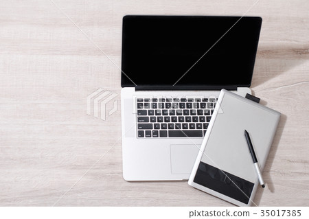 Open laptop and graphics tablet on a light table Open laptop and graphics tablet on a light table 35017385