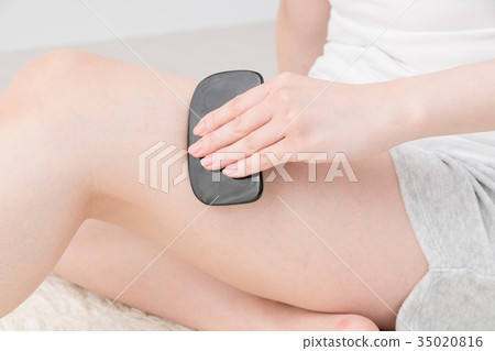 Woman doing self massage, intensity, thigh 35020816