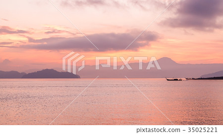 Pink sunrise sky and ocean with fishing boat  35025221