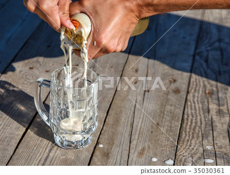 glass mug with beer on the table in the park 35030361