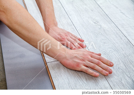 handyman laying down laminate flooring boards 35030569