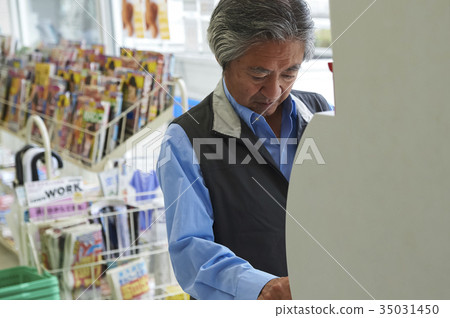 A man who uses a convenience store ATM A man who uses a convenience store ATM 35031450