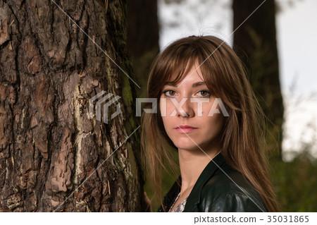young beautiful woman posing near big tree young beautiful woman posing near big tree 35031865