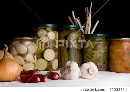 Jars with pickled vegetables on dark background Jars with pickled vegetables on dark background 35032524