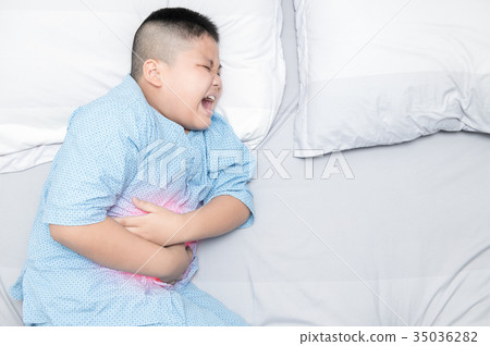boy suffering from stomachache on bed boy suffering from stomachache on bed 35036282
