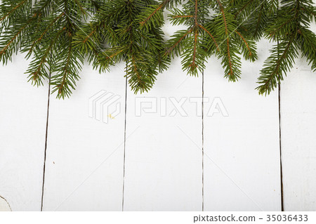 Fir branches on a white wooden background. Fir branches on a white wooden background. 35036433