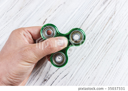 boy hand playing with fidget spinner gadget.  35037331