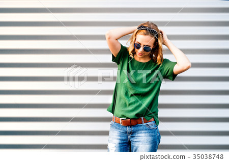 Young woman standing against the wall. Young woman standing against the wall. 35038748