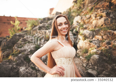 Attractive young woman in long dress standing on 35040532