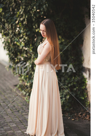 Beautiful girl with long hair posing near tree in 35040542