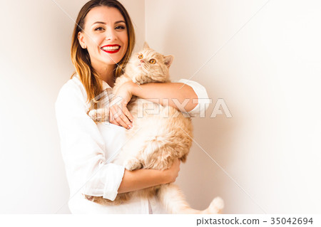 Beautiful girl with a red cat 35042694