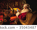 Santa Claus texting on a smartphone in workshop 35043487