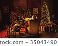 Wide shot of Santa in workshop using smartphone 35043490