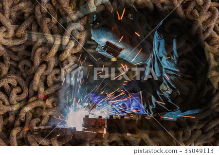 Worker is welding steel part in factory 35049113