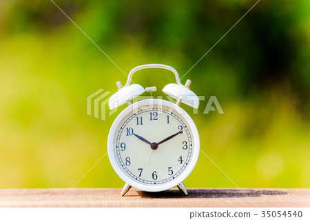Alarm clock and green blur background Alarm clock and green blur background 35054540