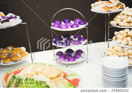 Delicious and tasty dessert table with cupcakes Delicious and tasty dessert table with cupcakes 35060202