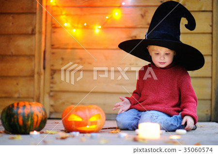 Little wizard playing with halloween pumpkins Little wizard playing with halloween pumpkins 35060574