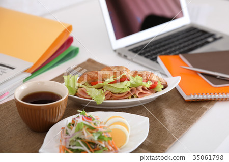 Eating sandwiches with salad and coffee at work 35061798