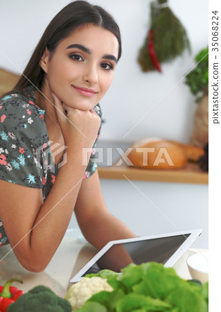 Young hispanic woman or student cooking in kitchen 35068224