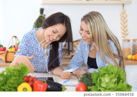 Two young happy women making online shopping for 35068438
