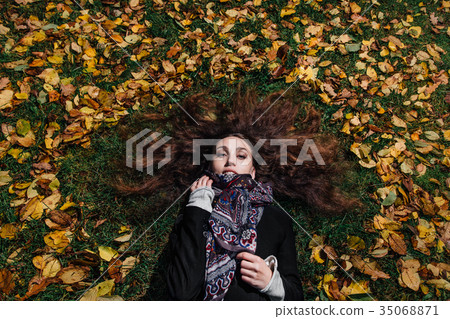 Fall portrait of a girl lying on a lawn in a Fall portrait of a girl lying on a lawn in a 35068871