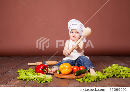 the boy chef with a wooden spoon, carrots, peppers 35069991