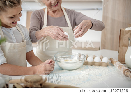 Happy grandmother teaching girl to make dough Happy grandmother teaching girl to make dough 35071328