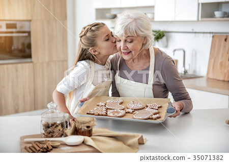 Happy child thanking grandma for sweet pastry 35071382