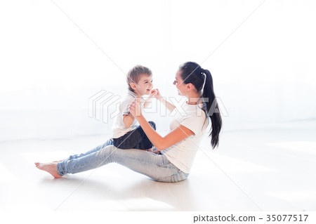mom plays with her son on the floor of the 35077517