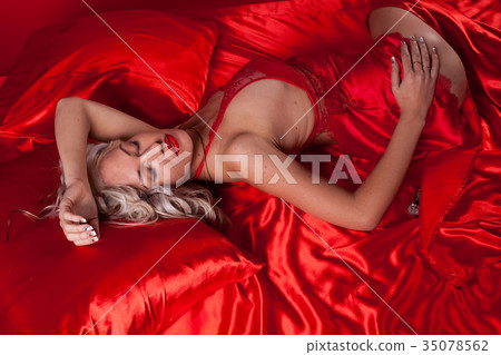 sexy blonde in red underwear lies on a bed sexy blonde in red underwear lies on a bed 35078562