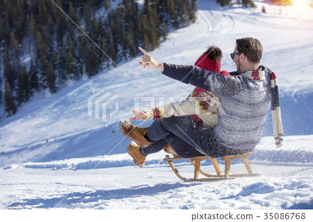 Young Couple Sledding And Enjoying On Sunny Winter 35086768