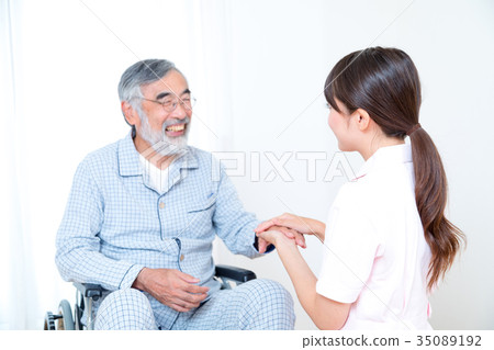 Young nurse and grandpa hold hands Hand touch Retirement home Day care center Wheelchair Young nurse and grandpa hold hands Hand touch Retirement home Day care center Wheelchair 35089192