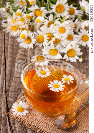 Herbal tea with fresh chamomile flowers on old Herbal tea with fresh chamomile flowers on old 35089395
