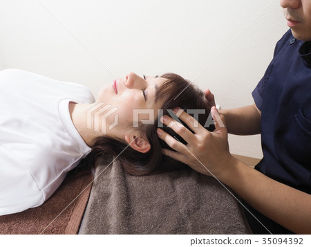 Woman receiving small face massage Woman receiving small face massage 35094392