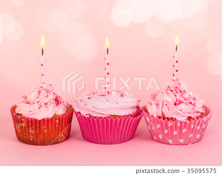 Row of three cupcakes with candles 35095575