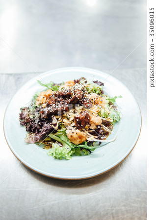 Caesar salad in a white plate on a metal surface Caesar salad in a white plate on a metal surface 35096015
