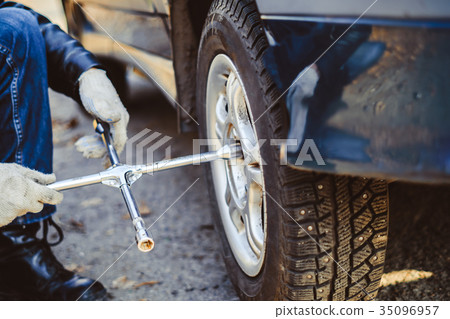 man changing wheel on a car 35096957