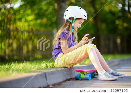 Pretty little girl learning to skateboard 35097105