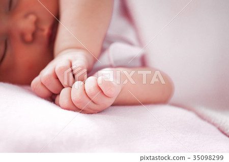 Newborn baby hand on pink blanket 35098299