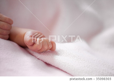 Newborn baby hand on pink blanket 35098303