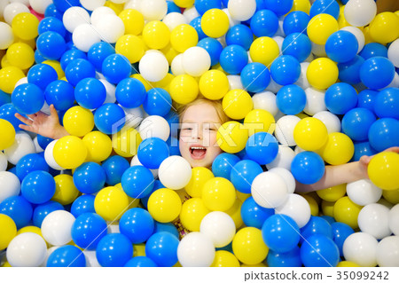 Happy little girl having fun in ball pit in kids indoor play center 35099242