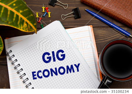 Notebook with a notes GIG ECONOMY on the office 35100234