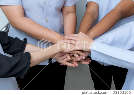 Doctor and nurses in a medical team stacking hands 35103100