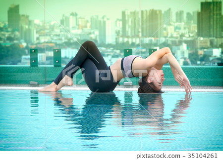 young women doing yoga pose at the swimming pool young women doing yoga pose at the swimming pool 35104261