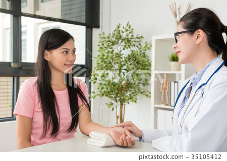 smiling pretty woman doctor touching patient hand 35105412