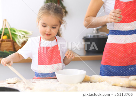 Mother and her cute daughter prepares the dough at Mother and her cute daughter prepares the dough at 35113706