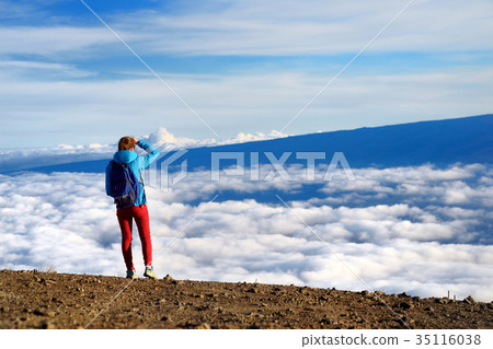 Tourist admiring breathtaking views from the Mauna Kea, a dormant volcano on the island of Hawaii Tourist admiring breathtaking views from the Mauna Kea, a dormant volcano on the island of Hawaii 35116038